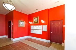 Orange apartment for rent - Mail room with red walls and mail boxes