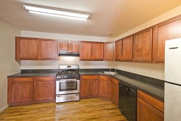 Orange apartment for rent - a kitchen with wooden cabinets and stainless steel appliances