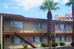 Las Vegas apartment for rent - a building with stairs and a palm tree in front of it