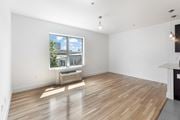 Jersey City apartment for rent - an empty living room with a large window and wooden floors
