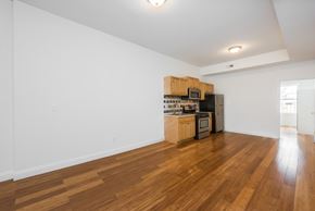 Jersey City apartment for rent - the living room and kitchen of an apartment with wood flooring and