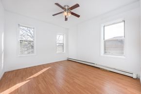 Jersey City apartment for rent - an empty room with wood floors and a ceiling fan