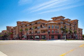 Los Angeles apartment for rent - A large multi-story building with a parking lot in front.