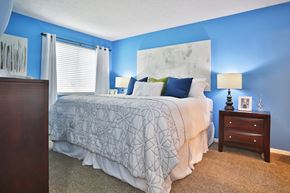 Cincinnati apartment for rent - a bedroom with a bed and blue walls and a window