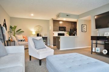 Cincinnati apartment for rent - a living room and kitchen with a couch and a chair