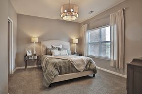 Jeffersontown townhouse for rent - A bedroom with a large bed and a chandelier.