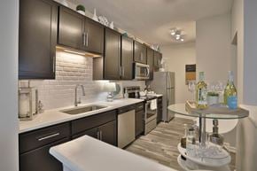West Chester townhouse for rent - A modern kitchen with dark brown cabinets and a white countertop.