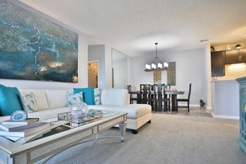 West Chester townhouse for rent - A modern living room with a large painting on the wall and a dining area in the background.