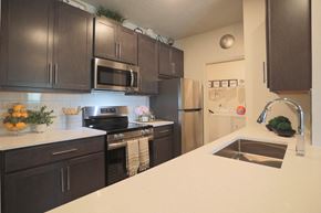 Centerville townhouse for rent - A kitchen with dark brown cabinets and a white countertop.
