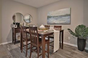 Loveland apartment for rent - a dining room with a table and chairs and a painting on the wall