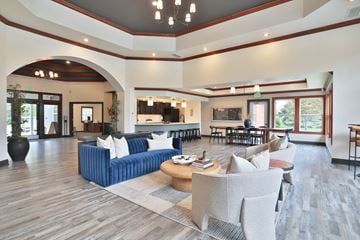Fishers townhouse for rent - A large, modern living room with a blue sofa and wooden floors.