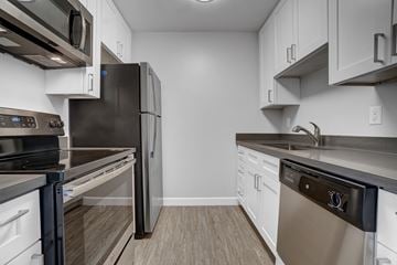 Mountain View apartment for rent - an empty kitchen with stainless steel appliances and white cabinets