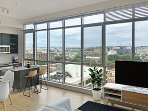 Washington apartment for rent - A modern living room with a view of the cityscape outside the large windows.