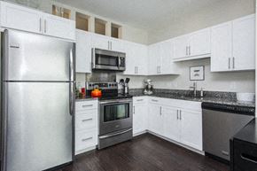 Allston apartment for rent - a kitchen with stainless steel appliances and white cabinets