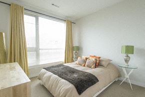 Allston apartment for rent - a bedroom with a bed and a large window