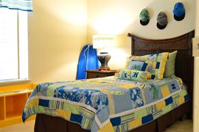 Glen Burnie apartment for rent - a bedroom with a bed and a blue surfboard in the corner