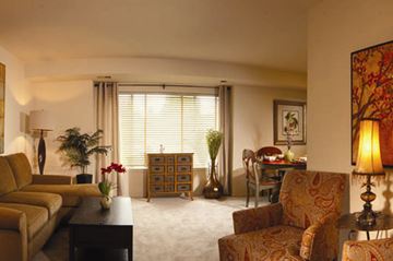 Essex apartment for rent - A living room with a couch, chairs, and a table with a vase of flowers on it.