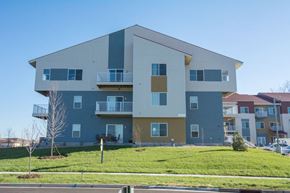 Cottage Grove apartment for rent - a building with two levels and a green lawn
