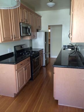 San Francisco apartment for rent - an empty kitchen with wooden floors and wooden cabinets