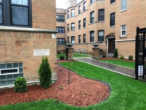 Chicago apartment for rent - an apartment building with a green yard and grass