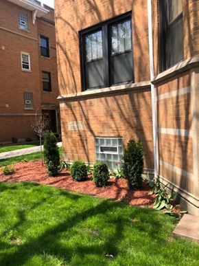 Chicago apartment for rent - a garden in front of a brick building