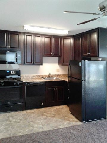 Shillington apartment for rent - a kitchen with black appliances and dark wood cabinets