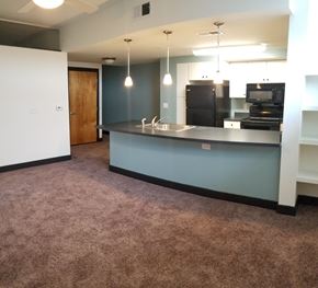 Richmond apartment for rent - an empty living room with a kitchen with a blue counter top