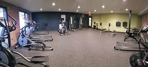 Richmond apartment for rent - a gym with cardio equipment and weights on the floor