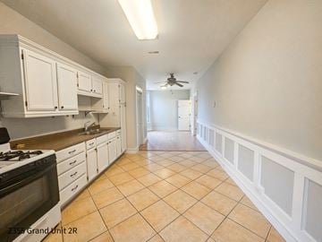 Chicago apartment for rent - a kitchen with white cabinets and tiled floors and a ceiling fan