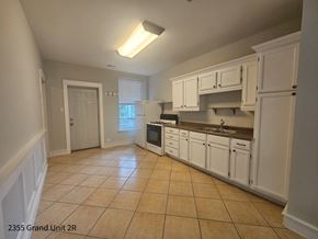 Chicago apartment for rent - a kitchen with white cabinets and tiled floors and a sink