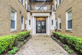 Montclair apartment for rent - the front entrance of a condo building with a brick walkway and manicured gardens