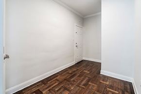 Montclair apartment for rent - a bedroom with white walls and wood flooring and a door