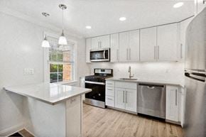 Springfield apartment for rent - an all white kitchen with stainless steel appliances and white cabinets