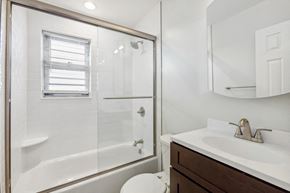 Orange apartment for rent - a bathroom with a shower and a sink and a toilet