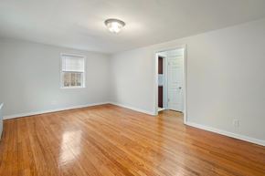 Bloomfield apartment for rent - an empty living room with wood floors and a door to a closet