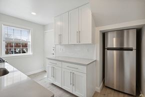 Edison apartment for rent - a kitchen with white cabinets and a stainless steel refrigerator