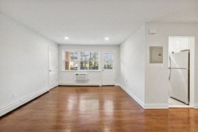 Clark apartment for rent - an empty living room with a refrigerator and a window