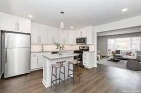 Scotch Plains apartment for rent - a kitchen with white cabinets and a white island with two stools