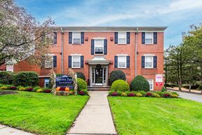 Verona apartment for rent - the front of a brick building with a green lawn and a sidewalk