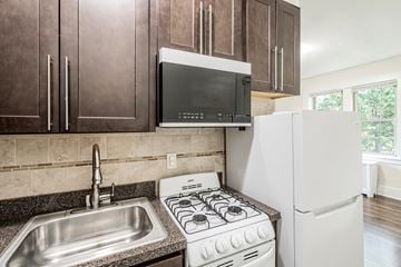 Bloomfield apartment for rent - a kitchen with a stove and a sink and a microwave