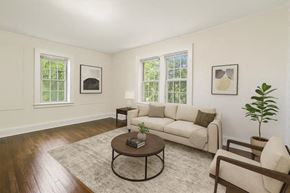 Bloomfield apartment for rent - A living room with a white couch, a coffee table, and two windows.