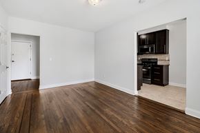 Bloomfield apartment for rent - an empty living room with wood flooring and a kitchen