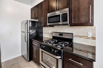 Bloomfield apartment for rent - a kitchen with stainless steel appliances and wooden cabinets