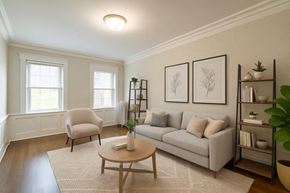 Bloomfield apartment for rent - A living room with a white couch, a chair, a coffee table, and a bookshelf.