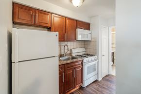 Bloomfield apartment for rent - an empty kitchen with white appliances and wooden cabinets