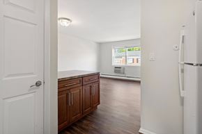 Bloomfield apartment for rent - an empty kitchen and living room with a refrigerator and a window