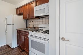 Bloomfield apartment for rent - a kitchen with a white stove and microwave and a refrigerator