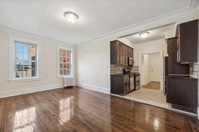 Bloomfield apartment for rent - the living room and kitchen of an empty house with wooden floors and a large window