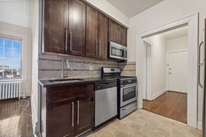 Bloomfield apartment for rent - a kitchen with wooden cabinets and appliances and a window