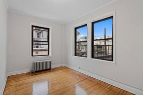Kearny apartment for rent - a living room with windows and a radiator and a wood floor
